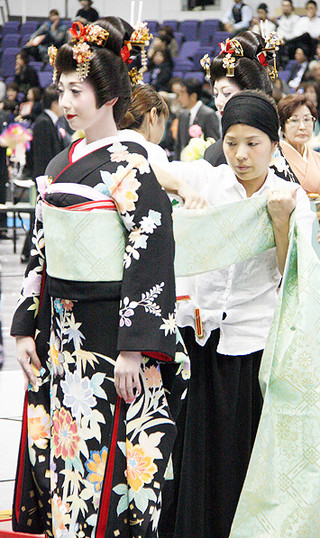 全日本美容技術選手権大会の花嫁化粧着付競技に挑む新城桃子さん＝20日、札幌市の北海きたえーる