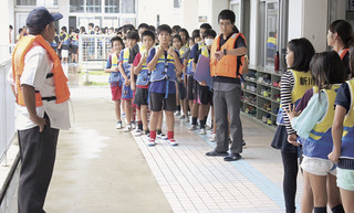 救命胴衣を着用し、廊下で整列する児童ら＝５日午前、新川小学校