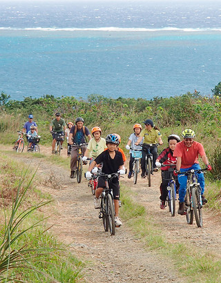 北部地域子どもパークレンジャーの活動で、平久保半島の東海岸をサイクリングする児童と保護者ら＝３日午前（エコツーリズム・環境教育「ふくみみ」提供）