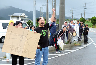 兄の応援で那覇から駆け付けた長浜拓さん（手前右）と妻の早耶さんら。通過する勤選手をガッツポーズで後押し＝６日午前、大里