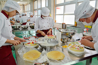 思い思いにデコレーションケーキを作る八重山農林高校アグリフード科の生徒たち＝21日午後、同校農産加工室