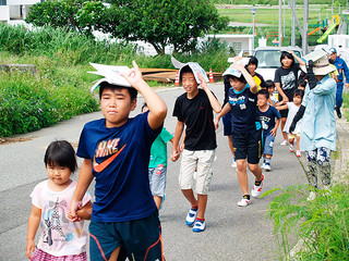 低学年の手を引き高台へ駆ける児童ら＝23日、祖納浦野台付近