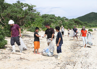 ウミガメ繁殖地保全事業として漂着物を回収する明石地区の住民ら＝10日午前、明石海岸