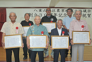 八重山地区農業機械士協議会の創立30周年記念式典で表彰状を手渡された受賞者ら＝16日夜、北京飯店