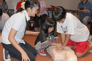 応急手当ての方法を学ぶ子どもたち＝９日午後、市民会館中ホール