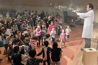 阿部清人氏が発射する煙の空気砲に大喜びの子どもたち＝10日午後、市民会館中ホール