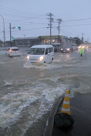 猛烈な雨で国道３９０号は深い所で水位が約80㌢まで達した＝５日午後３時４分、真栄里北交差点