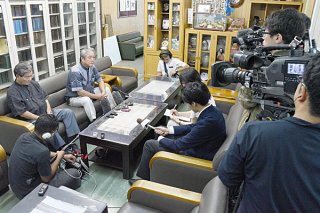 県内外メディアから今後の対応について取材を受ける外間守吉町長（左から２人目）＝30日午後、町長室