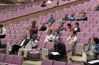防衛省沖縄防衛局の住民説明会に出席する市民。疑問や不満をぶつけた＝13日夜、市民会館大ホール