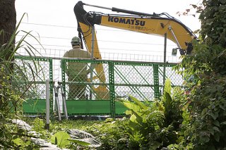 転圧作業を行うショベル。沖縄防衛局は５日、造成にかかる掘削工事を開始した＝５日午後、旧ジュマールゴルフガーデン入り口付近
