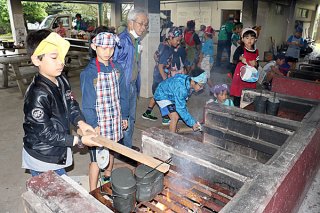 お米を炊くためまきを燃やす児童たち＝９日午後、県立石垣青少年の家