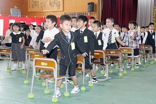 「ドキドキドン！一年生」を踊り、入学の喜びを表す新入生ら＝９日午前、石垣小学校体育館