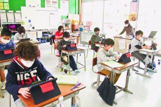 授業の始めに、ＡＩ教材の「ｅライブラリ」を使って問題を解く児童ら＝2月25日午後、名蔵小中学校