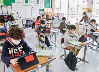 ＧＩＧＡスクール構想で整備されたタブレット端末を使って勉強する市内小中学校の児童ら＝2月25日、名蔵小中学校