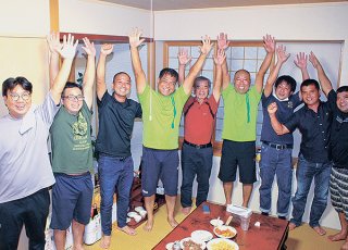 支持者と初当選を喜ぶ田盛英伸さん（左から4人目）＝11日深夜、大浜の自宅兼事務所