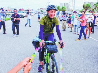 自転車による「15歳の日本縦断」を達成し、祝福を受ける松村陽向さん＝26日午後、石垣漁港フィッシャリーナ