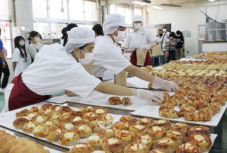 注文を受けた種類のパンを次々と取り上げていく生徒ら＝4日午前、八重山農林高校