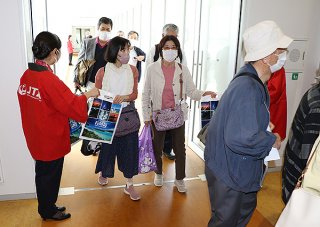 新潟空港からのチャーター便で到着した観光客をＪＴＡ職員が歓迎した＝6日午後、南ぬ島石垣空港