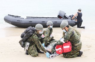 与那国町主催の防災訓練の一環で、海上に漂流する負傷者をボートで救助する与那国駐屯地自衛隊員ら＝12日、ナーマ浜